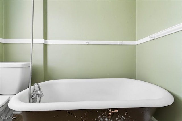 bathroom featuring toilet and a soaking tub