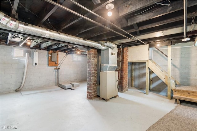 below grade area with heating unit, electric panel, and stairs