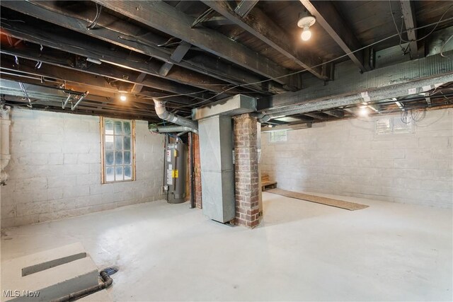 basement with water heater, heating unit, and plenty of natural light