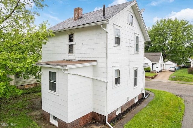 view of property exterior with a chimney and a shingled roof