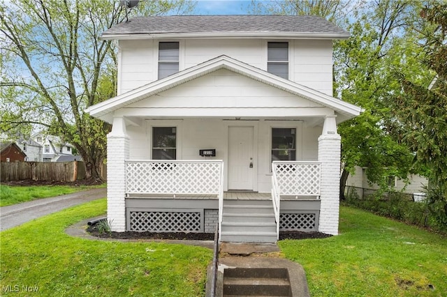 traditional style home with a porch and roof with shingles
