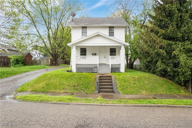 american foursquare style home with a porch and a shingled roof