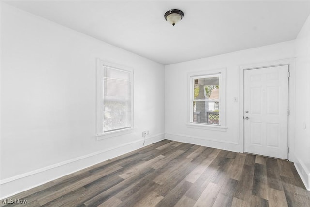 unfurnished room featuring dark wood-style flooring and baseboards