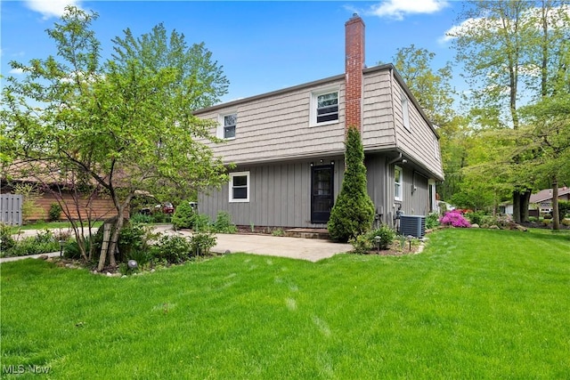 5550 Barton Rd, North Olmsted, OH 44070 - back of house featuring central AC, a chimney, board and batten siding, a yard, and a patio area
