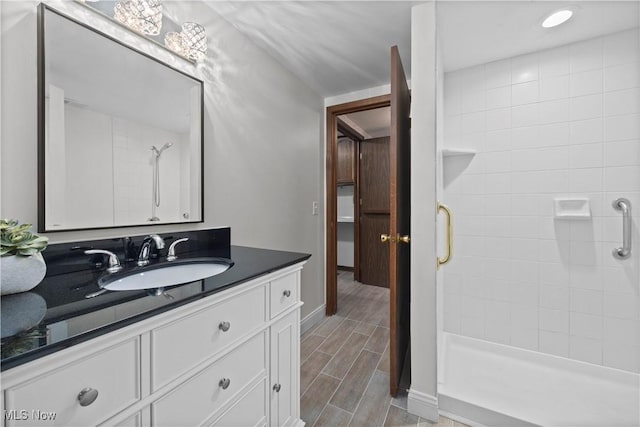 5550 Barton Rd, North Olmsted, OH 44070 - bathroom featuring a shower stall, vanity, wood finished floors, and baseboards