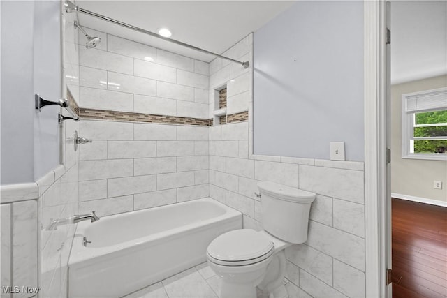 5550 Barton Rd, North Olmsted, OH 44070 - bathroom with tile walls, toilet, bathing tub / shower combination, and a wainscoted wall