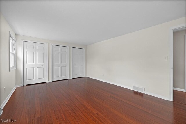 5550 Barton Rd, North Olmsted, OH 44070 - unfurnished bedroom featuring two closets, wood finished floors, and baseboards