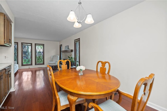 5550 Barton Rd, North Olmsted, OH 44070 - dining space featuring a chandelier, dark wood-type flooring, and baseboards