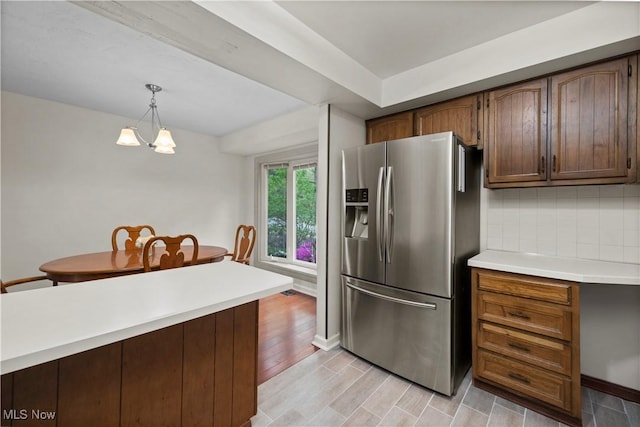 5550 Barton Rd, North Olmsted, OH 44070 - kitchen featuring stainless steel refrigerator with ice dispenser, light countertops, tasteful backsplash, decorative light fixtures, and light wood-type flooring