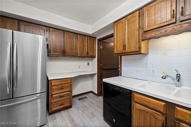 5550 Barton Rd, North Olmsted, OH 44070 - kitchen featuring freestanding refrigerator, dishwasher, tasteful backsplash, a sink, and light countertops