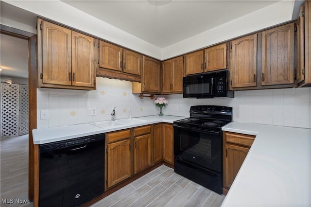 5550 Barton Rd, North Olmsted, OH 44070 - kitchen featuring black appliances, a sink, decorative backsplash, and light countertops