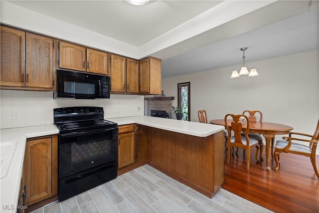 5550 Barton Rd, North Olmsted, OH 44070 - kitchen with black appliances, brown cabinets, a peninsula, and decorative backsplash