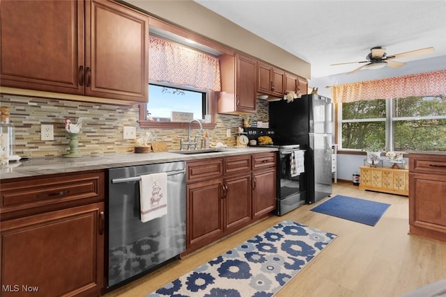 kitchen with stainless steel dishwasher, a sink, range with electric stovetop, and healthy amount of natural light