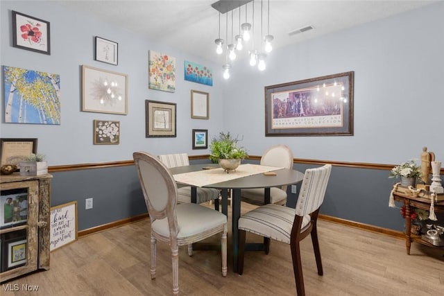 dining space featuring light wood-style floors and baseboards