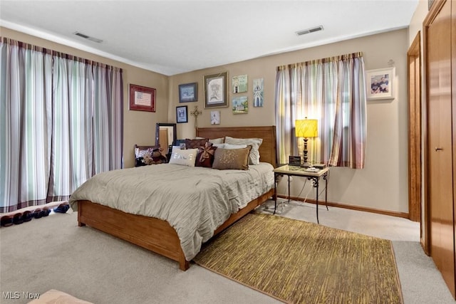 bedroom featuring light carpet and baseboards