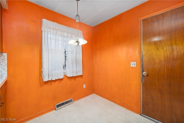 unfurnished dining area featuring carpet floors and baseboards
