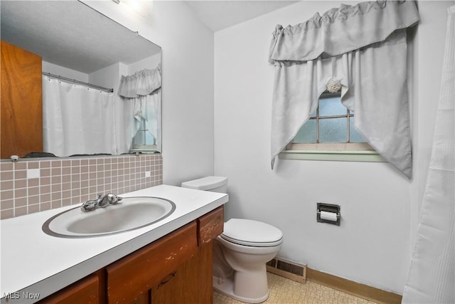 bathroom featuring decorative backsplash, toilet, vanity, baseboards, and a shower with curtain