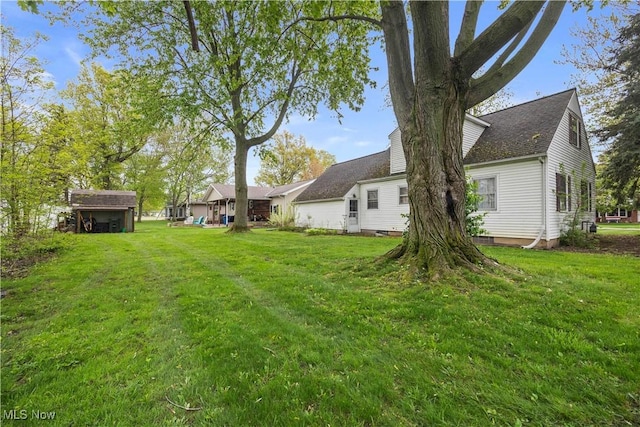 view of green lawn featuring a shed and an outbuilding