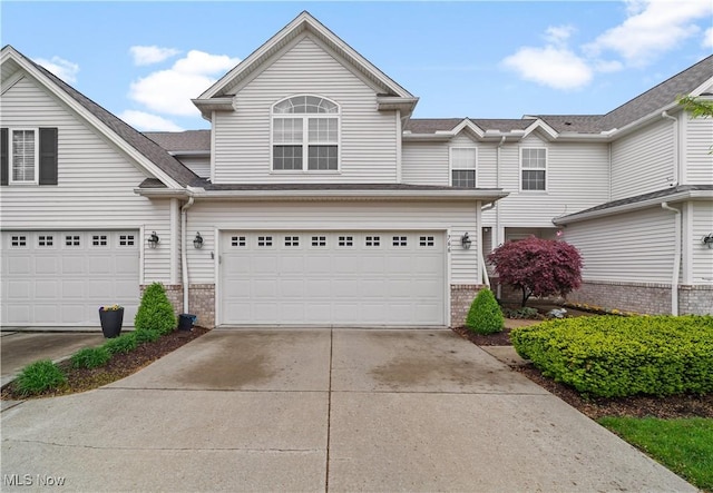 view of front of house featuring brick siding, driveway, and a garage