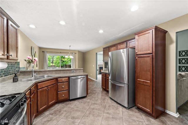 kitchen featuring appliances with stainless steel finishes, a peninsula, a sink, recessed lighting, and light tile patterned floors