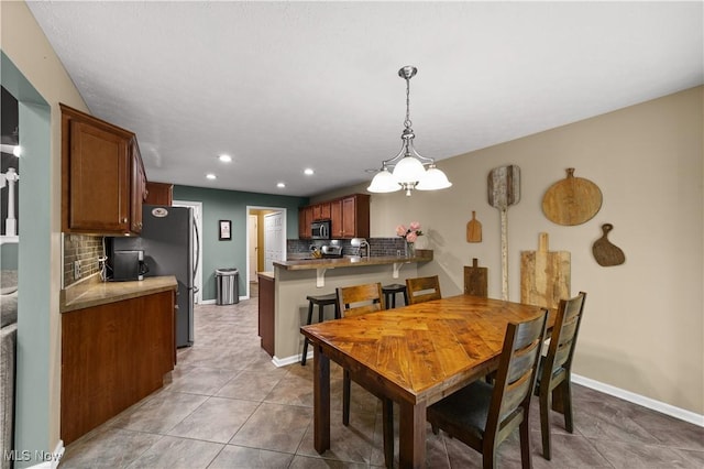 dining room featuring light tile patterned floors, recessed lighting, baseboards, and a chandelier