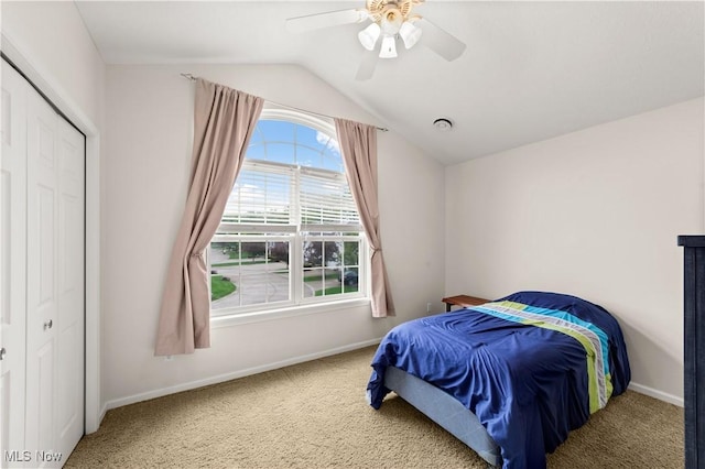 carpeted bedroom with vaulted ceiling, baseboards, ceiling fan, and a closet