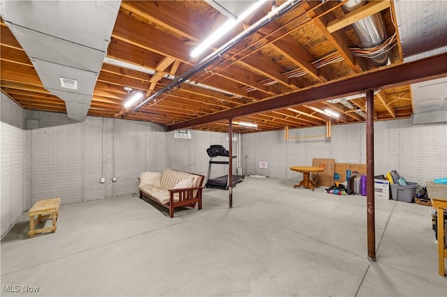 unfinished basement featuring brick wall