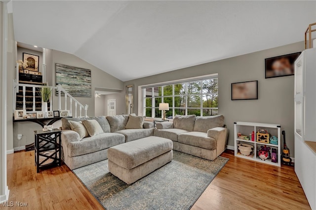 7805 Skylineview Dr, Mentor, OH 44060 - living room with stairs, vaulted ceiling, light wood-style floors, and baseboards