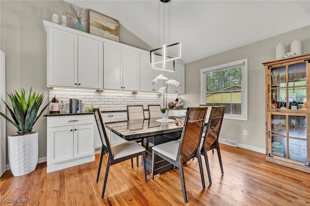 7805 Skylineview Dr, Mentor, OH 44060 - dining room with light wood-style floors, vaulted ceiling, baseboards, and a chandelier