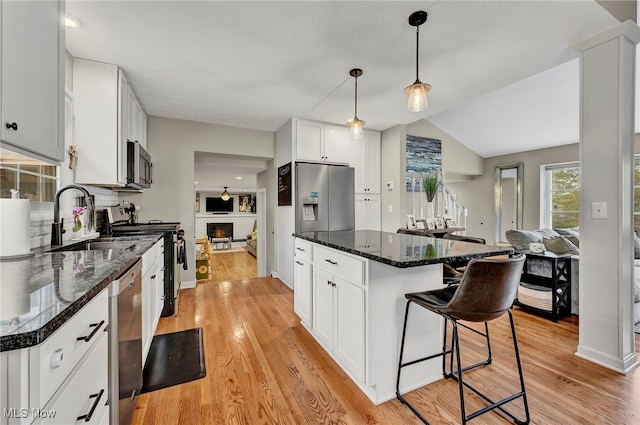 7805 Skylineview Dr, Mentor, OH 44060 - kitchen featuring appliances with stainless steel finishes, a sink, a breakfast bar area, open floor plan, and white cabinets