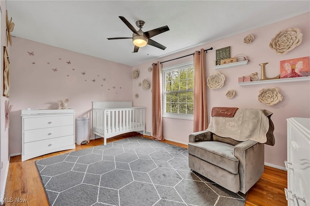 7805 Skylineview Dr, Mentor, OH 44060 - bedroom featuring wood finished floors, ceiling fan, baseboards, and a crib