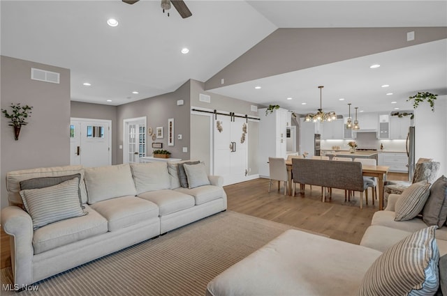 7440 Thatchum Ln, Concord, OH 44077 - living room featuring a barn door, ceiling fan, light wood finished floors, lofted ceiling, and recessed lighting