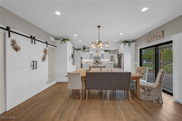 7440 Thatchum Ln, Concord, OH 44077 - dining room featuring a barn door, light wood-style flooring, a chandelier, recessed lighting, and baseboards