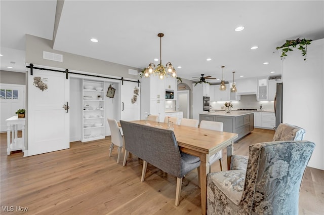 7440 Thatchum Ln, Concord, OH 44077 - dining area featuring a barn door, ceiling fan, light wood-style floors, and recessed lighting
