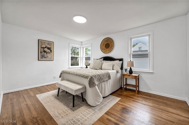 bedroom featuring dark wood finished floors and baseboards