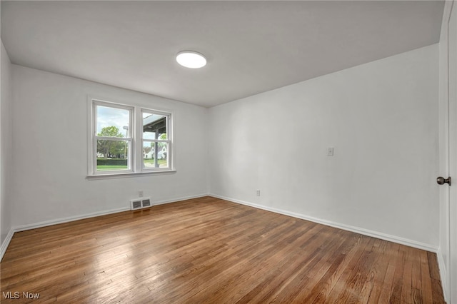 unfurnished room with hardwood / wood-style flooring and baseboards
