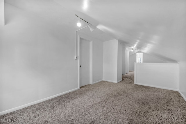 additional living space with vaulted ceiling, carpet flooring, and baseboards