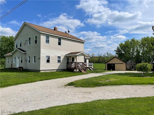 9207 Plank Rd, North Bloomfield, OH 44450 - back of property featuring a chimney, an outbuilding, a detached garage, a yard, and driveway