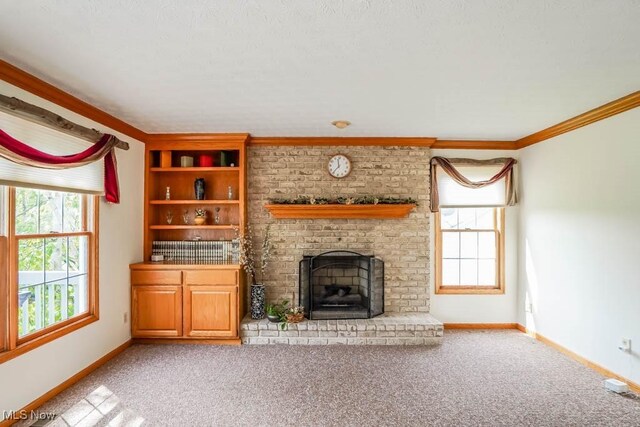 unfurnished living room with baseboards, a fireplace, carpet floors, and crown molding