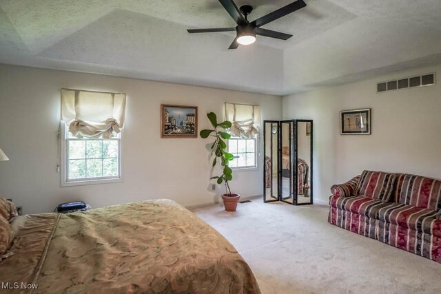 bedroom featuring multiple windows, carpet floors, a textured ceiling, and baseboards