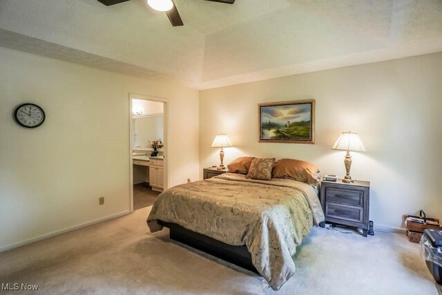 bedroom with light carpet, baseboards, ensuite bath, and a ceiling fan