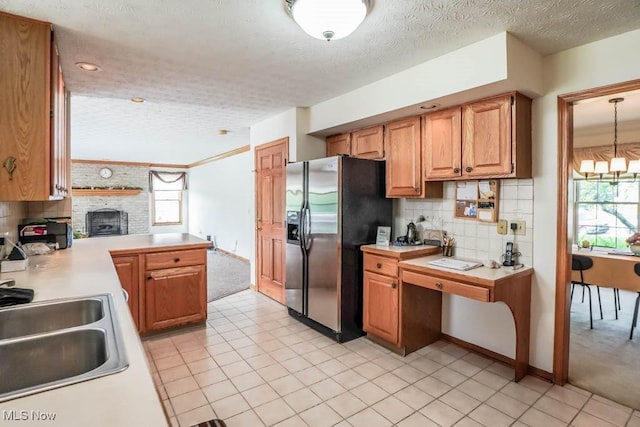 kitchen featuring stainless steel fridge, light countertops, backsplash, a textured ceiling, and light tile patterned floors