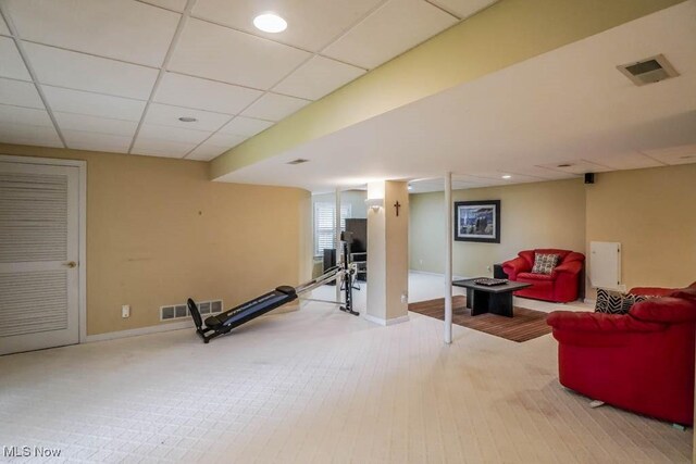 workout room featuring baseboards, a paneled ceiling, and carpet