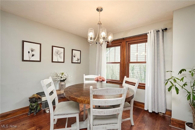 dining area featuring a chandelier, dark wood-type flooring, and baseboards