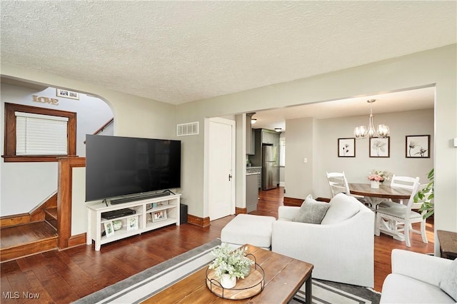 living area featuring wood finished floors, a chandelier, baseboards, and a textured ceiling