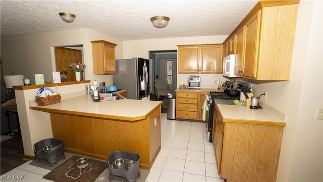 472 Vandalia Dr, Tallmadge, OH 44278 - kitchen featuring stainless steel appliances, a sink, a peninsula, light tile patterned floors, and light countertops