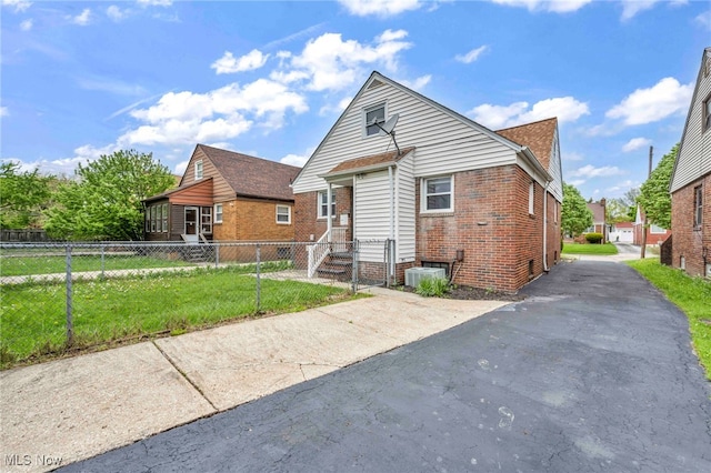 4110 Ellison Rd, South Euclid, OH 44121 - rear view of house featuring brick siding, central AC, and asphalt driveway
