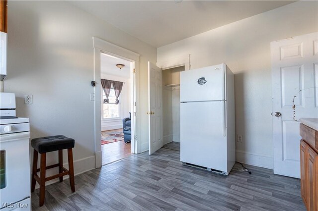 1016 12th St NE, Canton, OH 44704 - kitchen featuring white appliances, wood finished floors, and baseboards