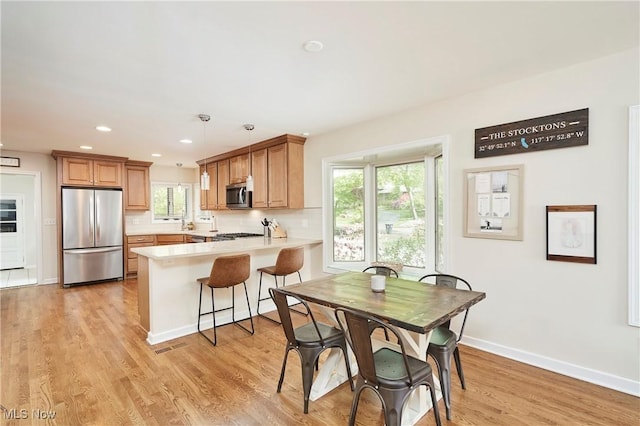 2530 Holgate Rd, Akron, OH 44313 - kitchen featuring appliances with stainless steel finishes, a peninsula, light countertops, light wood finished floors, and baseboards