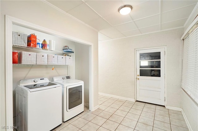 2530 Holgate Rd, Akron, OH 44313 - washroom featuring washer and clothes dryer, baseboards, brick wall, light tile patterned floors, and ornamental molding